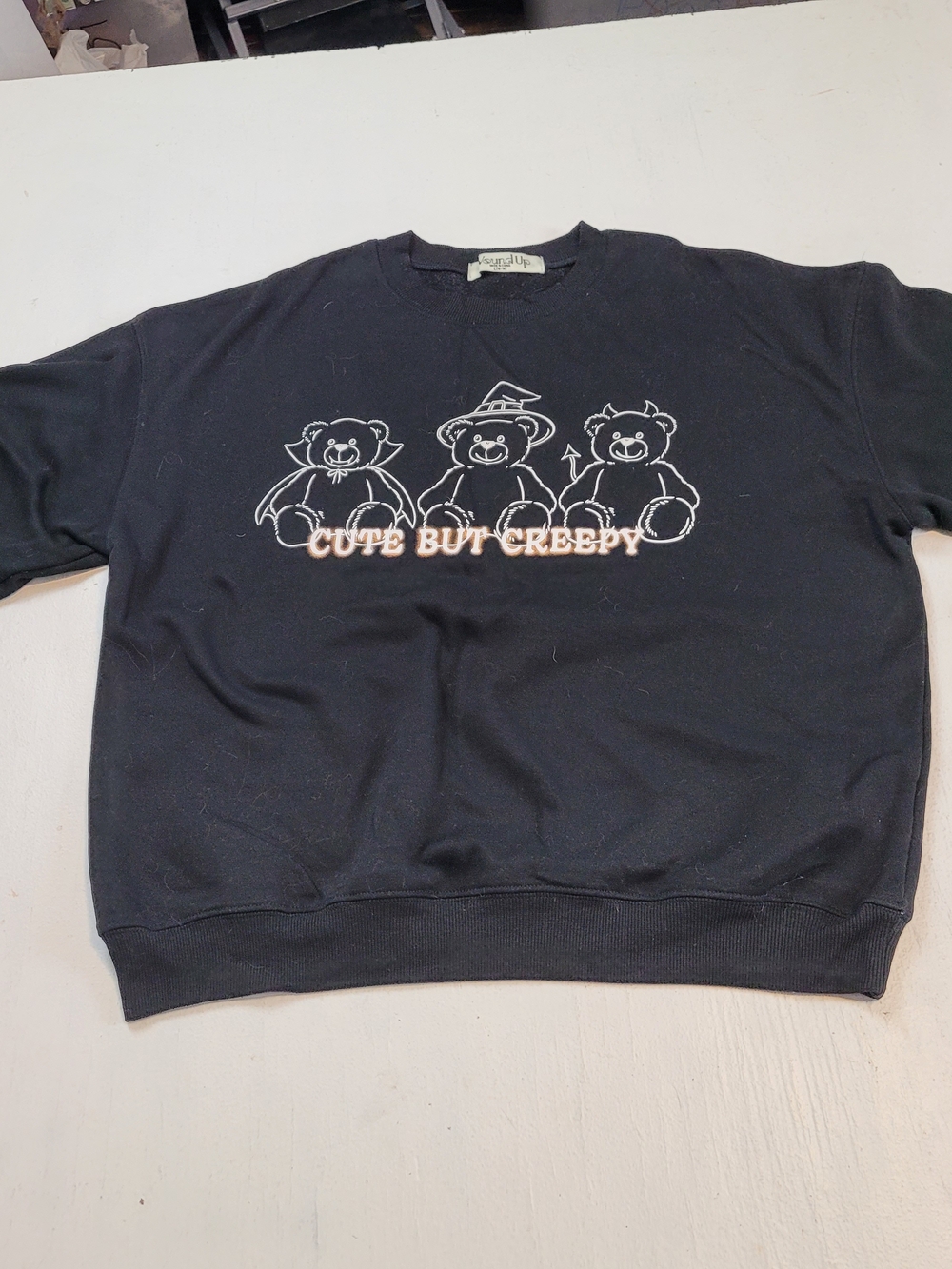 Wound Up Black Sweatshirt with White Teddy Graphic